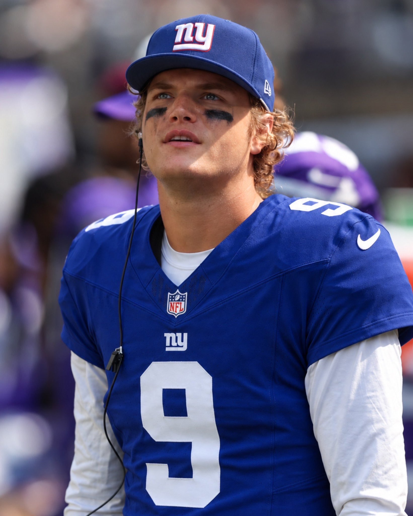 JJ McCarthy on the sideline in a New York Giants cap and #9 jersey