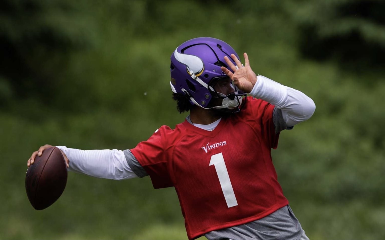 Kyler Murray throwing with hand obscuring his face